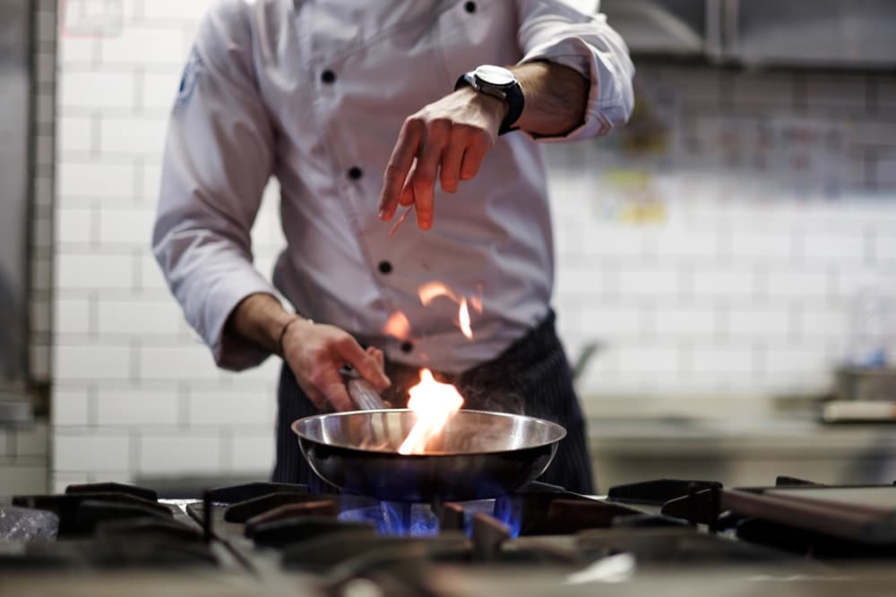 Chef cooking over blue gas flame