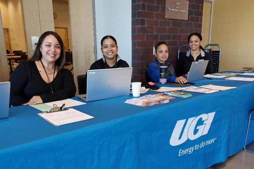 UGI Customer Assistance employees set up at table with laptop and brochures for an Energy Assistance Event