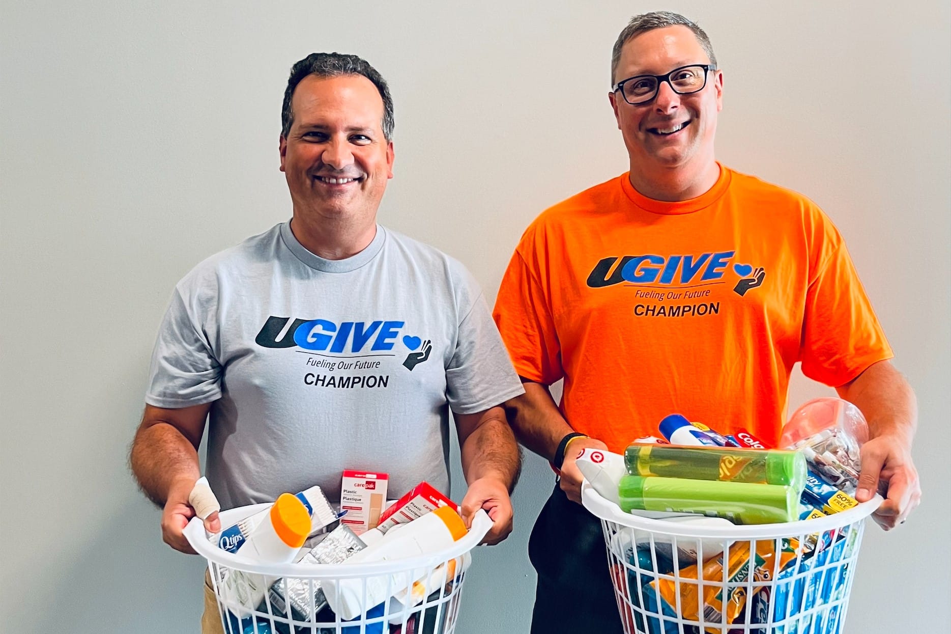 UGI employees wearing UGIVE shirts holding donation baskets of household items