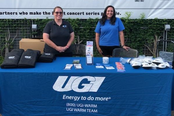 UGI employees standing at a booth with brochures and merch for Customer Assistance Programs