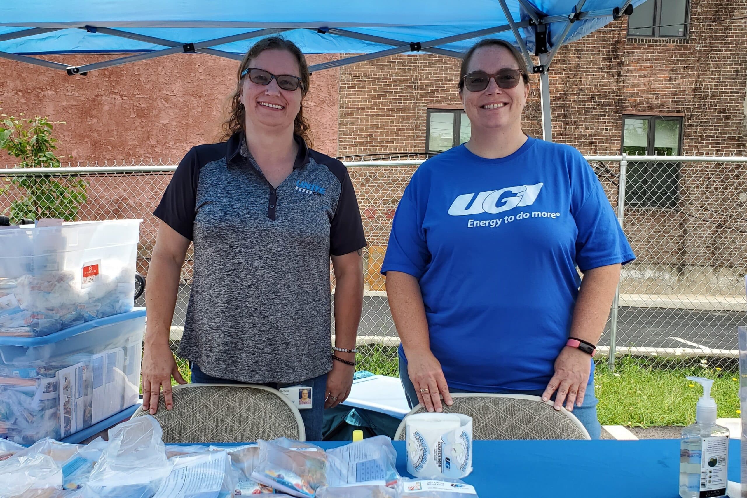 UGI employees standing at a booth with information packets for Customer Assistance Programs