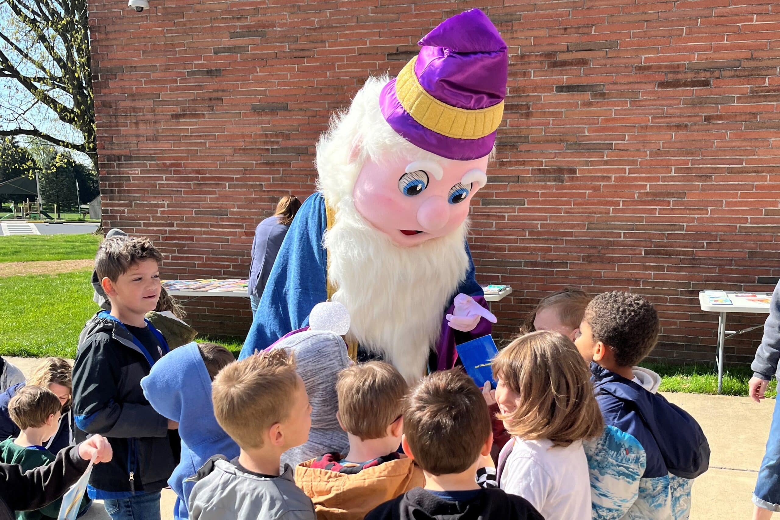 The Reading Wizard mascot talking to students