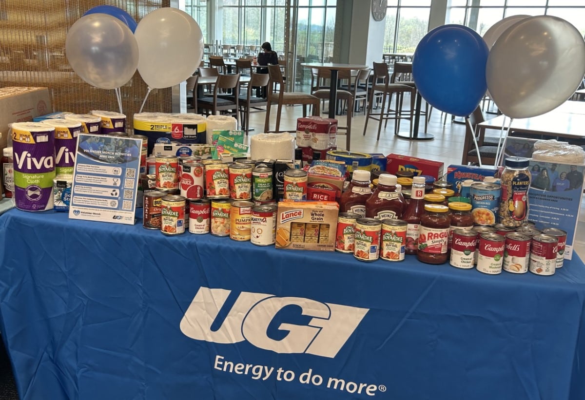 Food drive donations on a table with a UGI tablecloth.