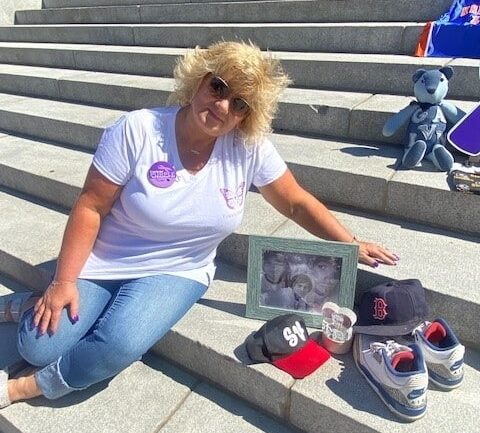 UGI employee Michele sits with a memorial for her son, including a photo of him and various sports memorabilia. 