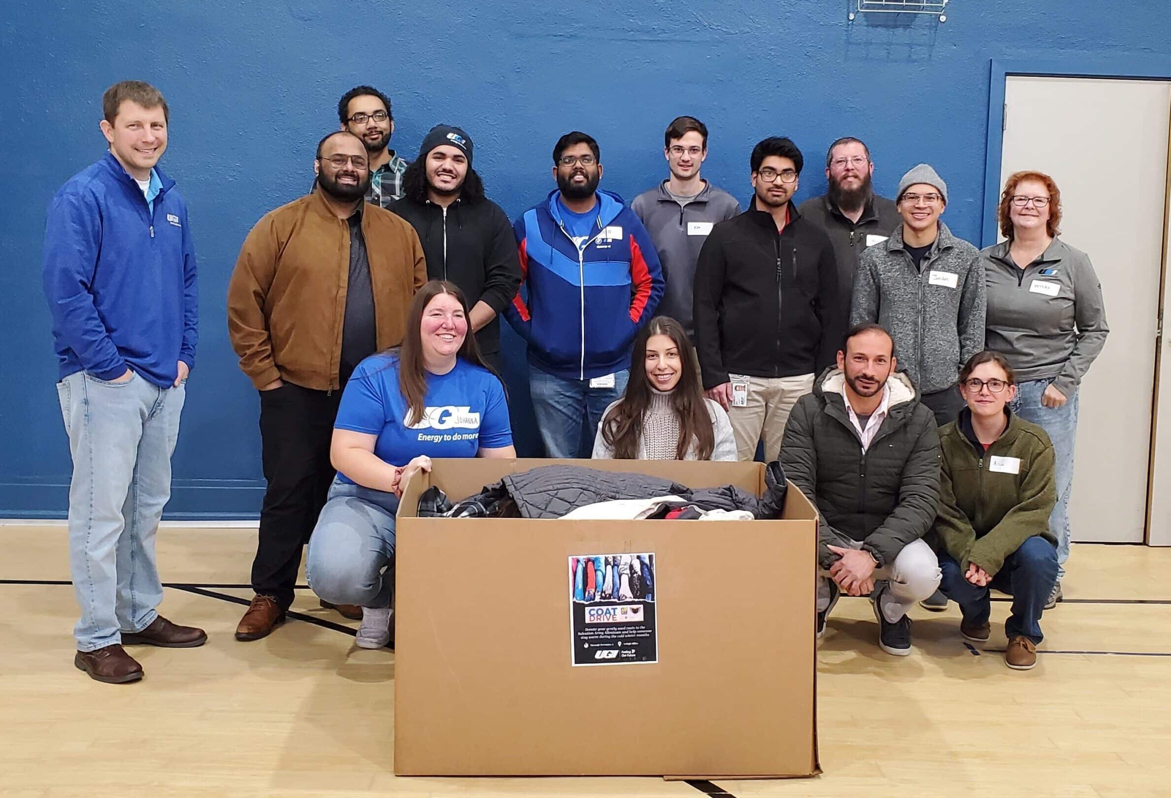 UGI employees smile with box of donated coats.