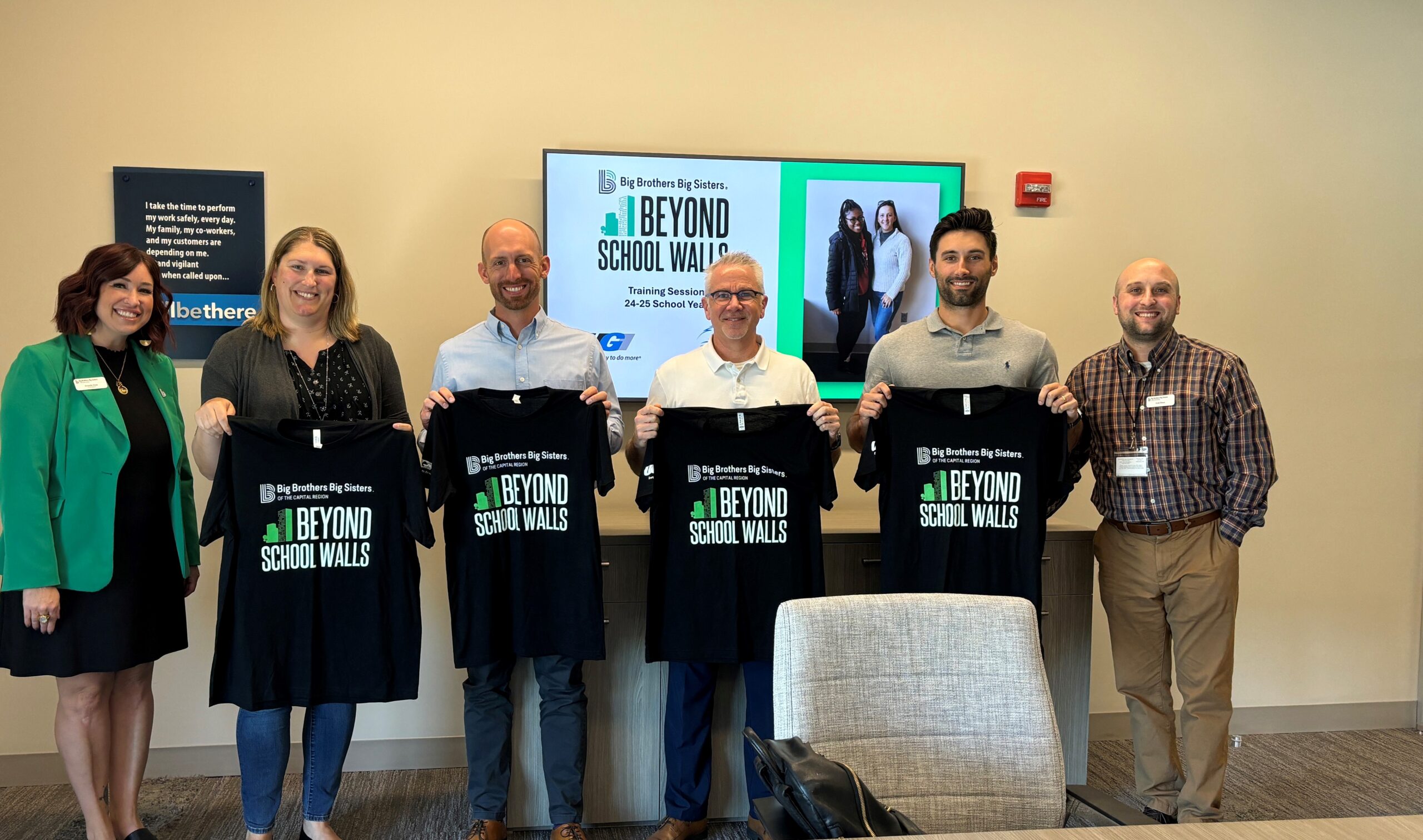 UGI mentors hold shirts that read Big Brothers Big Sisters Beyond School Walls.