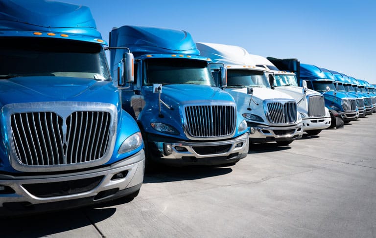 Fleet of blue 18 wheeler semi trucks