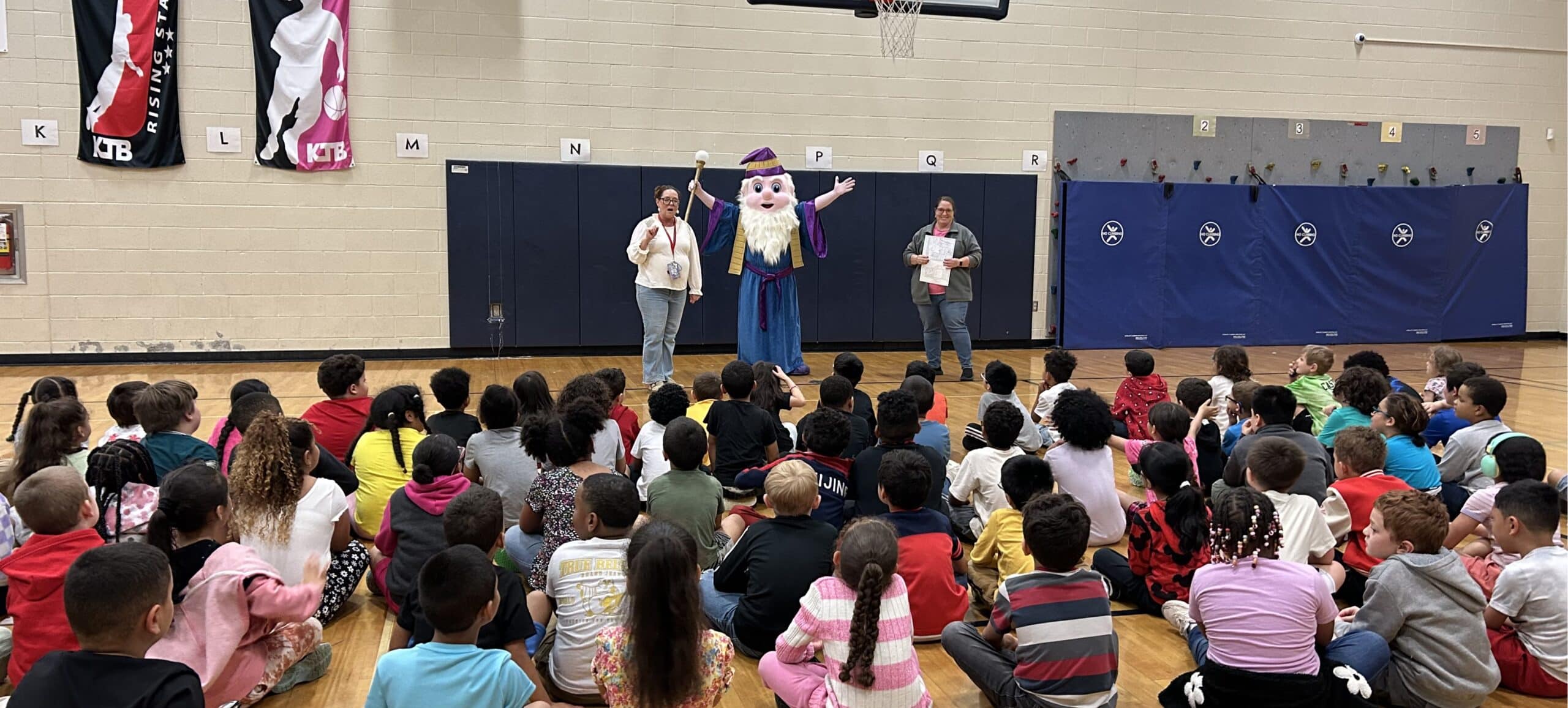 First grade students sit in front of the Reading Wizard and UGI employee.